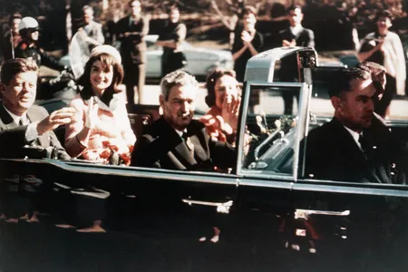 John F. Kennedy and Jackie Kennedy ride the presidential limousine through the streets of Dallas, Texas, on November 22, 1963. Texas Governor John B. Connally Jr. is seated in front of them.