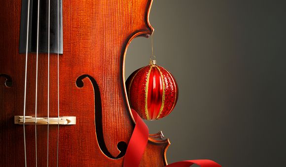 A portion of a violin is shown accented with red ribbon and an ornament