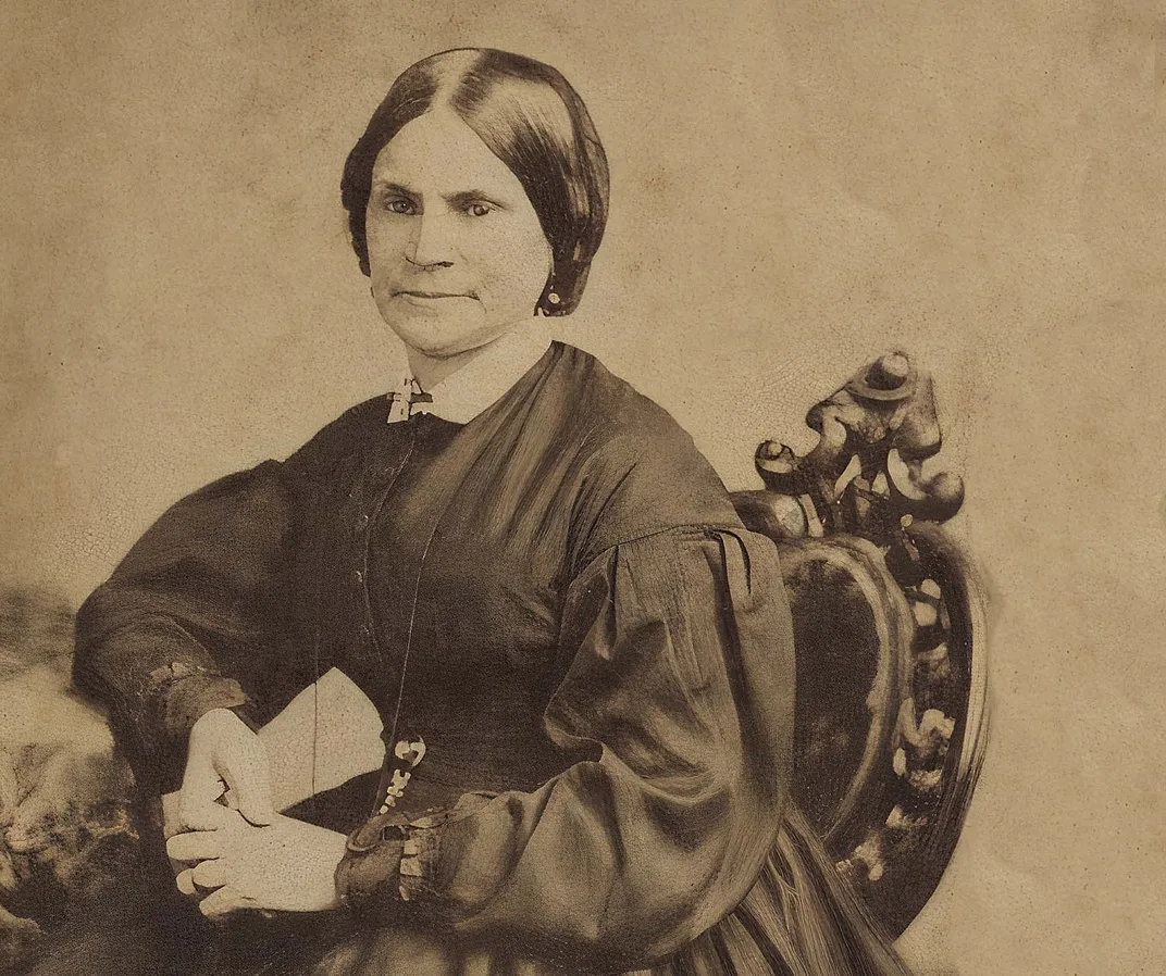 a sepia toned formal portrait of a woman sitting in a chair