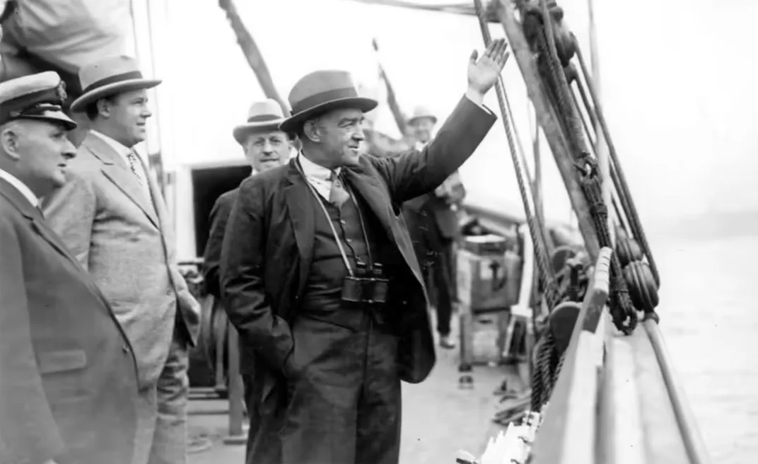 black-and-white photo of Ernest Shackleton looking out from a ship's deck