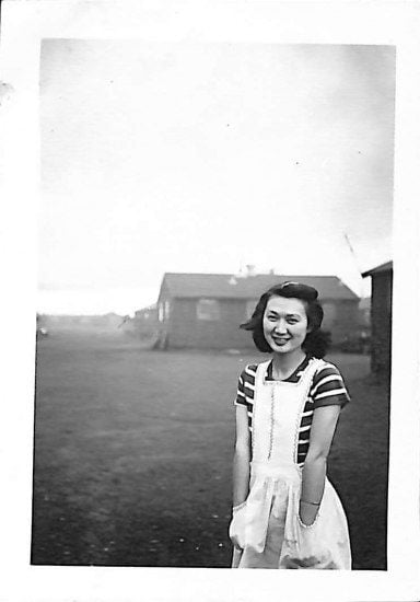 Black and white photo of young woman in white dress and striped shirt