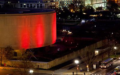 The Hirshhorn Museum is illuminated red in honor of World AIDS Day