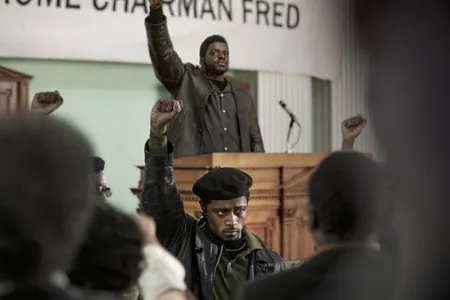Informer William O'Neal (played by LaKeith Stanfield, seen wearing a beret in the foreground) provided the FBI with information used to plan Black Panther Party Chairman Fred Hampton's assassination (portrayed by Daniel Kaluuya, standing with hand raised at the podium).
