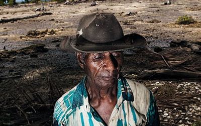 Posakei Pongap, a Manus islander, in front of a field ruined by salinization.