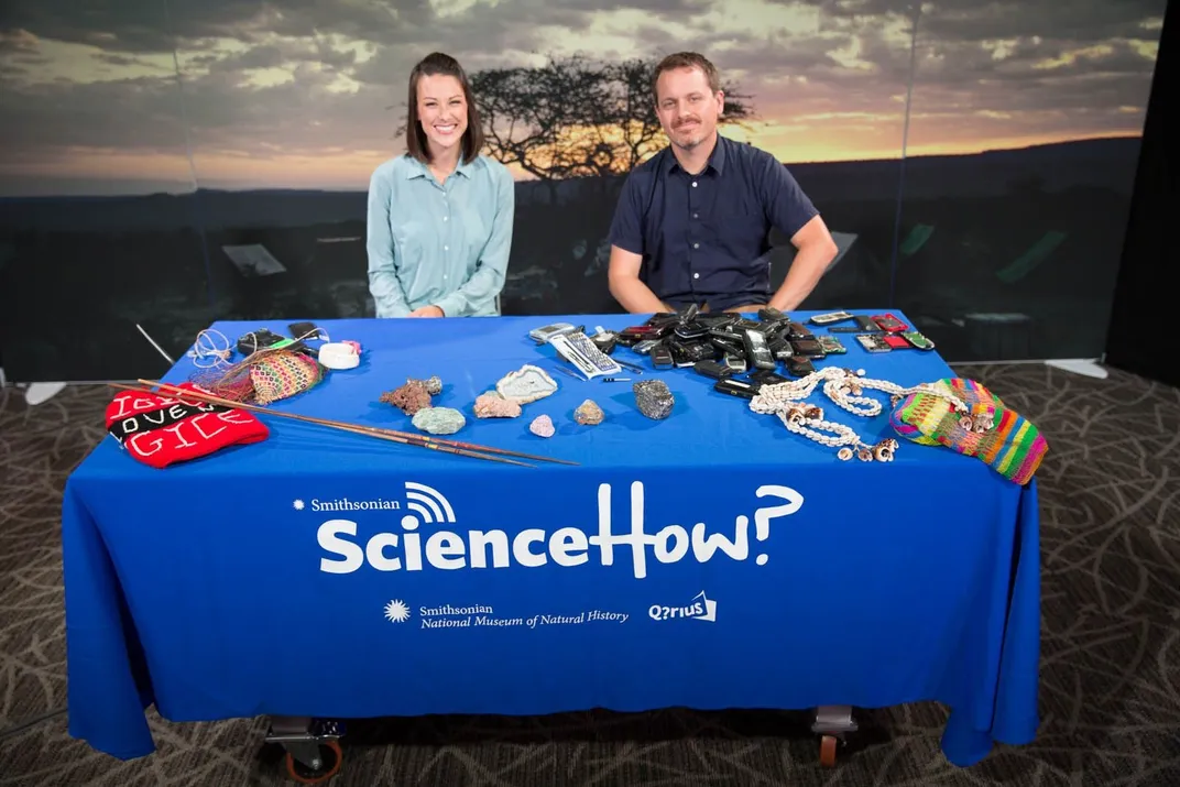 Two people sitting behind a table for a webcast.