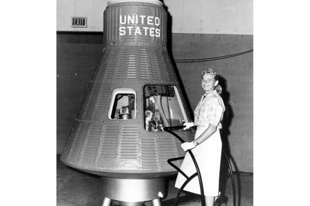 Jerrie Cobb stands before a Project Mercury space capsule in heels and gloves. What you can't see: inside the capsule, a male mannequin lies in the place where an astronaut eventually would. The FLATs were never seriously considered for astronaut positions.