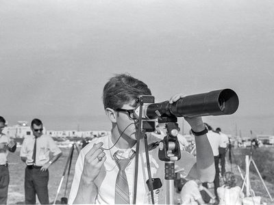 Using a borrowed 500mm lens, 18-year-old photojournalist Kevin L. Alexander, reluctantly wearing a necktie, takes aim at Kennedy Space Center launch pad 39A a few hours before the Saturn V’s history-making flight.