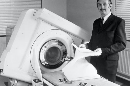 Godfrey Hounsfield stands beside the EMI-Scanner in 1972.