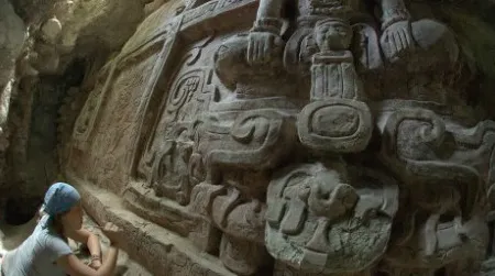An archeologist clearing debris away from an inscription on the newly discovered frieze.