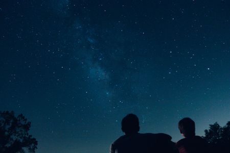 A pair of silhouetted people stargaze