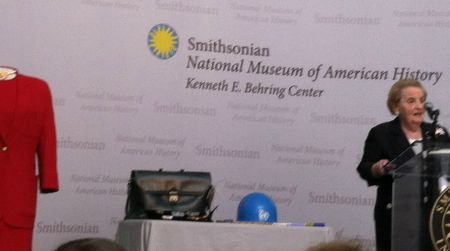 Former Secretary of State Madeleine Albright presents her red dress and other memorabilia at the American History Museum's joint naturalization-donation ceremony.