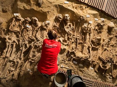 An archeologist from Inrap excavates a mass grave below a supermarket in Paris