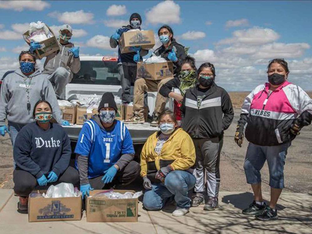 Volunteers with the Navajo & Hopi Families Covid-19 Relief Fund distribute food and other essential supplies to isolated communities and farmsteads on the Navajo Nation and Hopi Reservation. As part of the Smithsonian's virtual program 24 Hours in a Time of Change, Shandiin Herrera (Diné)—seated on the left, wearing a Duke University sweatshirt—describes how this grassroots response to the COVID-19 pandemic came together last spring and shares her experiences as the fund's volunteer coordinator in Monument Valley, Utah. (Photo by Karney Hatch)