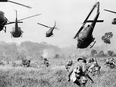 U.S. Army helicopters pour machine-gun fire into the tree line to cover the advance of South Vietnamese ground troops as they attack a Viet Cong camp 18 miles north of Tay Ninh, near the Cambodian border, in March 1965.