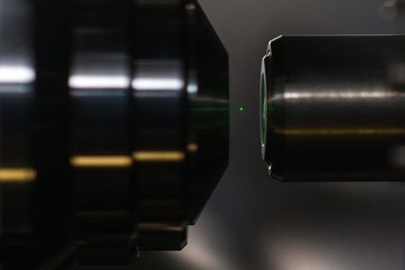 A silica sphere with a radius of 50 nanometers is trapped levitating in a beam of light.