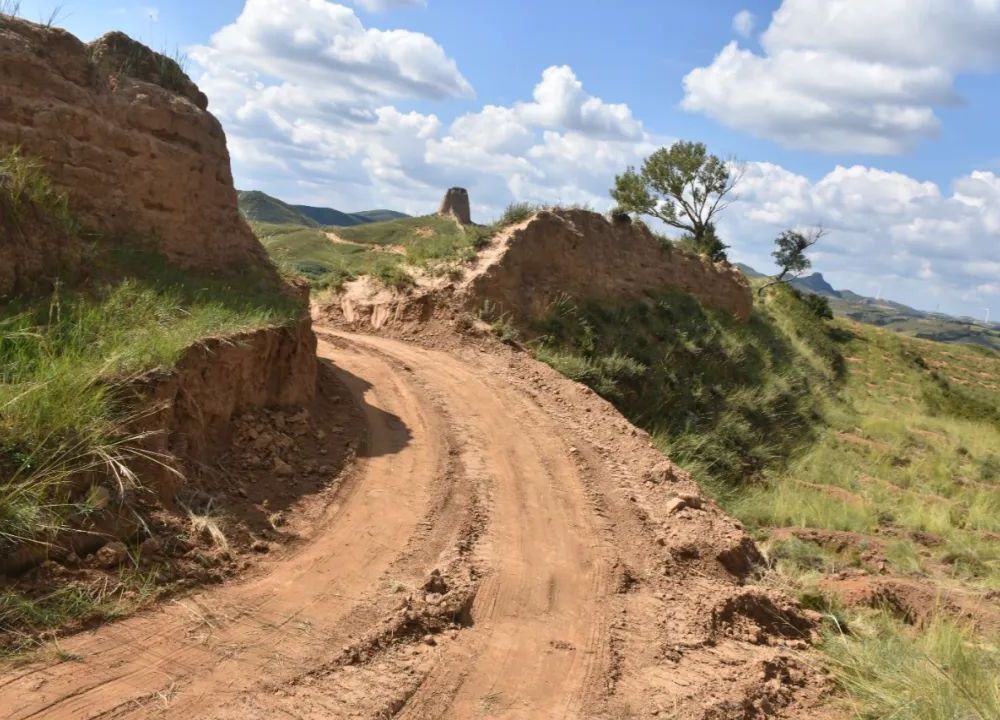 Dirt tire tracks running through gap in Great Wall