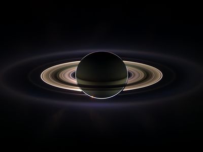 Saturn as seen by Cassini:  Some of you dust particles aren’t from around here, are you?