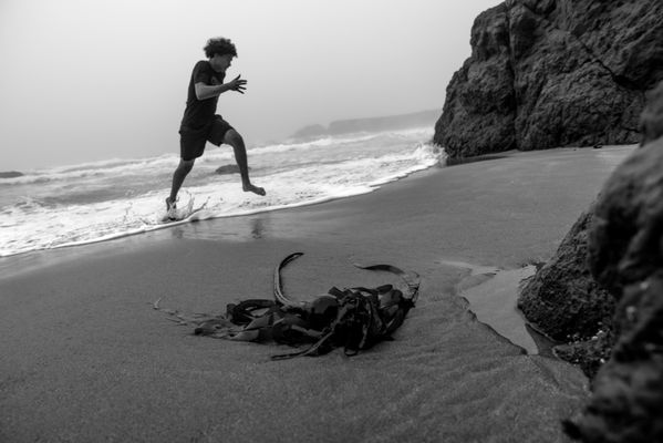 Boy running out of the ocean surf thumbnail