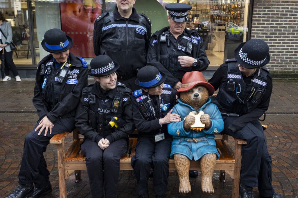 Police officers posing around statue of bear