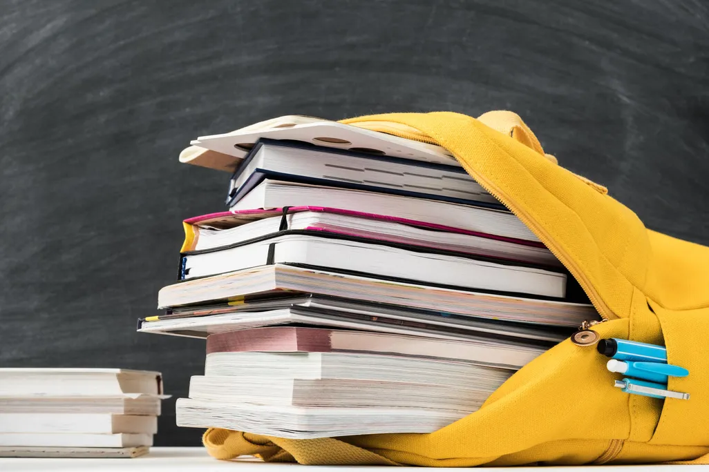 yellow backpack stuffed with books