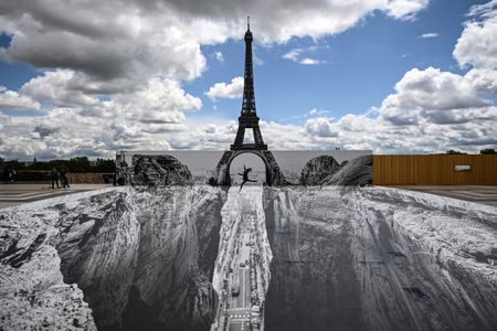 JR's newest illusion seemingly opens up a ravine in front of the Eiffel Tower.