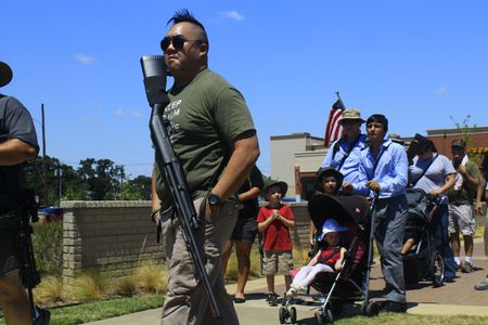 Believing that a large gun presence deters crime and makes Texas safer, almost forty long gun rights activists, slinging long guns over their shoulders and backs, joined in a walking rally calling for less restrictive open carry gun legislation. Arlington, 2013.  
