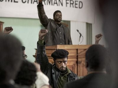 Informer William O'Neal (played by LaKeith Stanfield, seen wearing a beret in the foreground) provided the FBI with information used to plan Black Panther Party Chairman Fred Hampton's assassination (portrayed by Daniel Kaluuya, standing with hand raised at the podium).