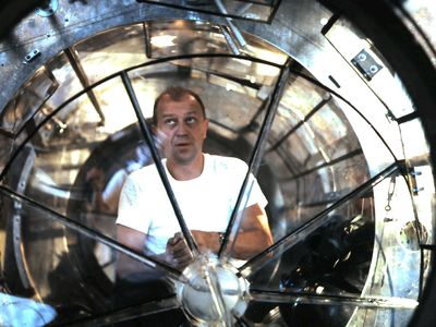 Mattingly inspects an airlock made for Gemini astronauts to practice spacewalks underwater.