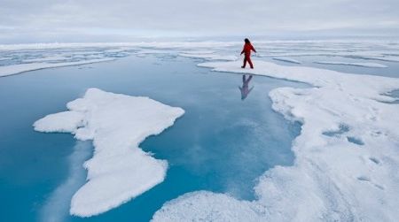 In this image from Science on Ice, graduate student Maria Tausendfreund collects a water sample from an Arctic melt pond during a brief period of 'ice liberty.'