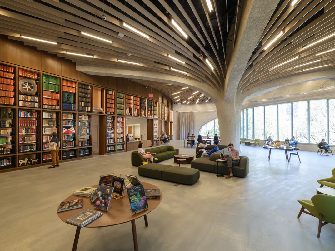 well-lit library with bookshelves and spread out tables