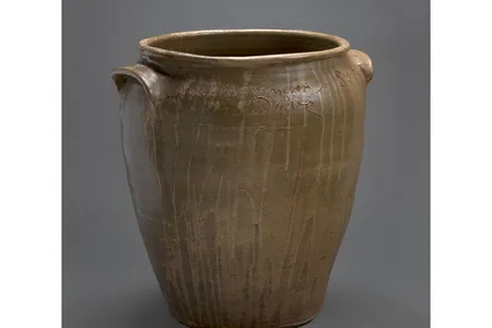 A brown-green vessel bearing the inscription, "A noble Jar for pork or beef / then carry it a round to the indian chief" made by the enslaved craftsman David "Dave" Drake, is now on view at the Smithsonian American Art Museum.