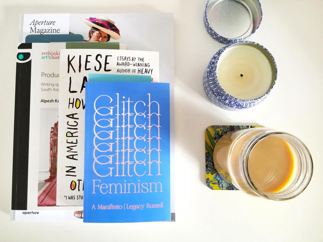 A photograph of books and a candle