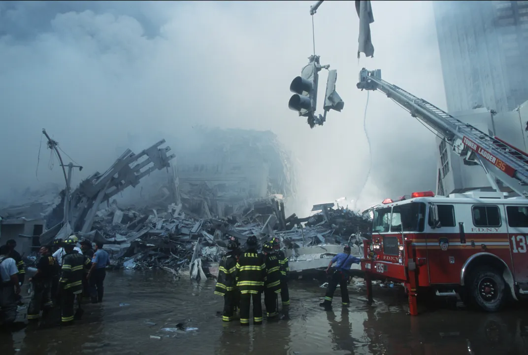 A view of Ground Zero, where water had flooded most of the scene and a traffic light is hanging by a thread over the scene. A firetruck sits nearby.