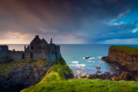 The sun sets on ruins of this medieval castle in Northern Ireland. In Dunluce Castle, Northern Ireland on May 01, 2011.
