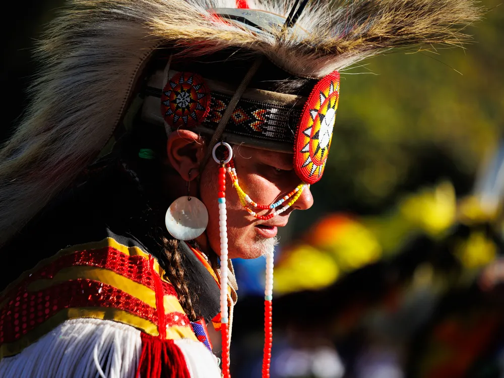 OPENER - A member of the Muscogee Creek Nation pauses at the edge of the dance circle in traditional regalia at an event in Nashville.