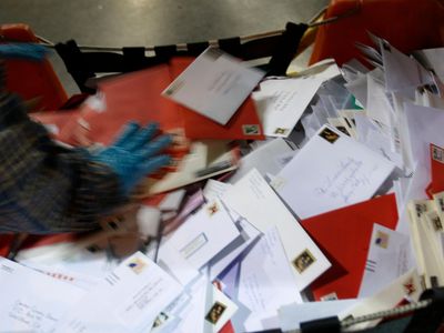 A pile of letters wait to be loaded in a sorting machine at a USPS processing and distribution center.