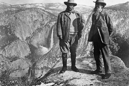 Theodore Roosevelt stands with naturalist John Muir on Glacier Point, above Yosemite Valley, California, USA.