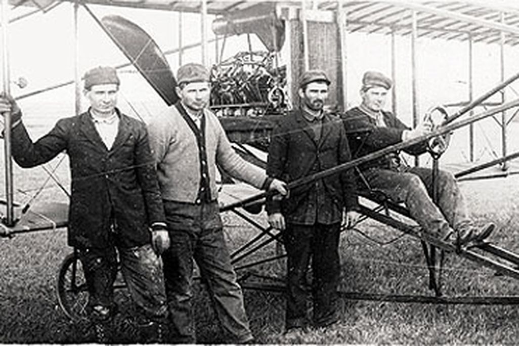 John, Joe, George, and Matt Savidge (from left) with one of their biplanes, ca. 1912.