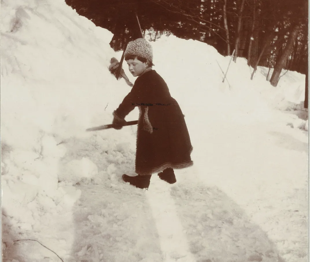 A young Alexei shoveling snow
