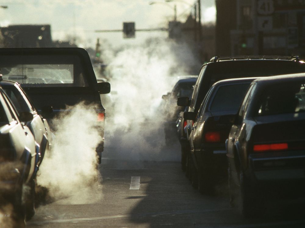 Smoke billows from two lines of cars' exhaust pipes