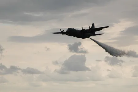 An Air Force Reserve Command C-130 Hercules equipped with a modular airborne fire fighting system gives an exhibition by dropping about 3,000 gallons of water at an airshow in Oshkosh, Wis. The Experimental Aircraft Association's AirVenture attracts hundreds of thousands of aviation enthusiasts from all over the world. The aircraft is assigned to the 302nd Airlift Wing at Peterson Air Force Base, Colo. (U.S. Air Force photo/Capt. Jeff Schoen)