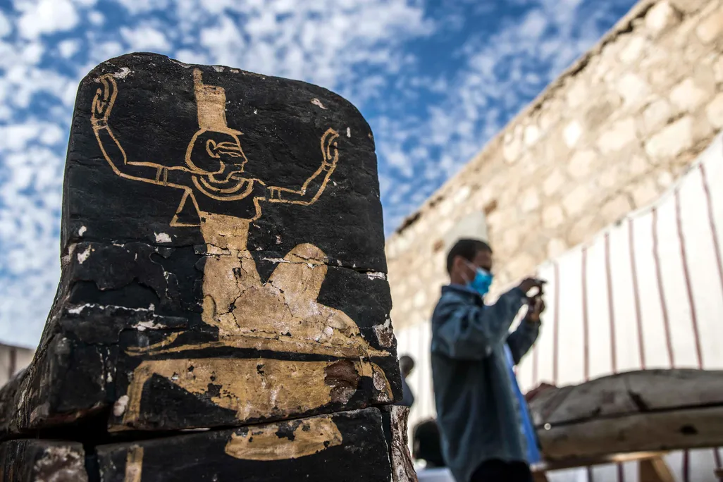 Tourist stands next to wooden coffin unearthed at Saqqara