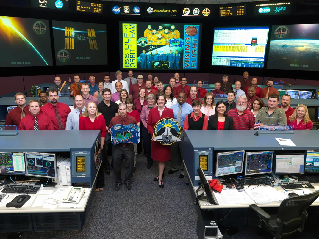 group portrait of flight controllers for space shuttle Atlantic, wearing red