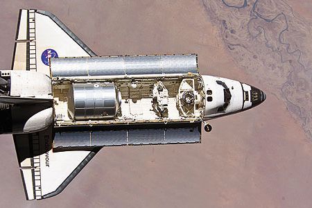 The shuttle main engine is the most tested large rocket engine in the world. In 1996, a turbine component (displayed here by a NASA scientist) underwent airflow tests to help engineers create more efficient aircraft engines.