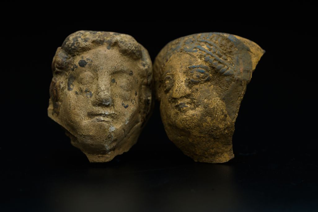 two stone fragments of faces