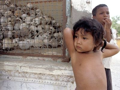 Children stand near a memorial at Cambodia’s killing fields