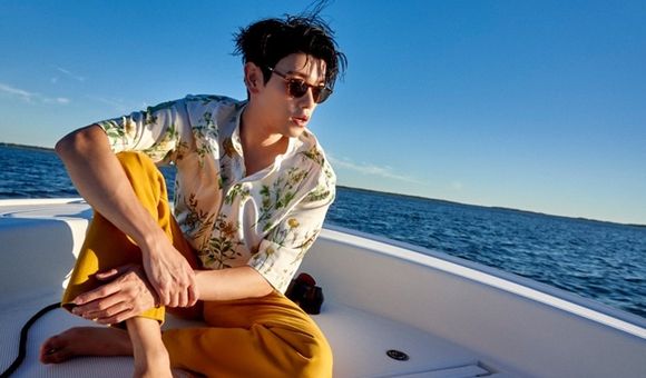 Eric Nam sitting on a boat in the ocean
