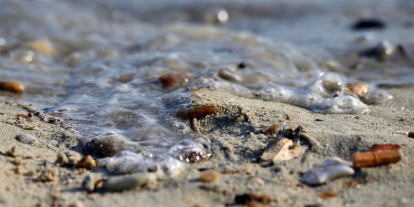 Sea waves coming through sand pebbles thumbnail