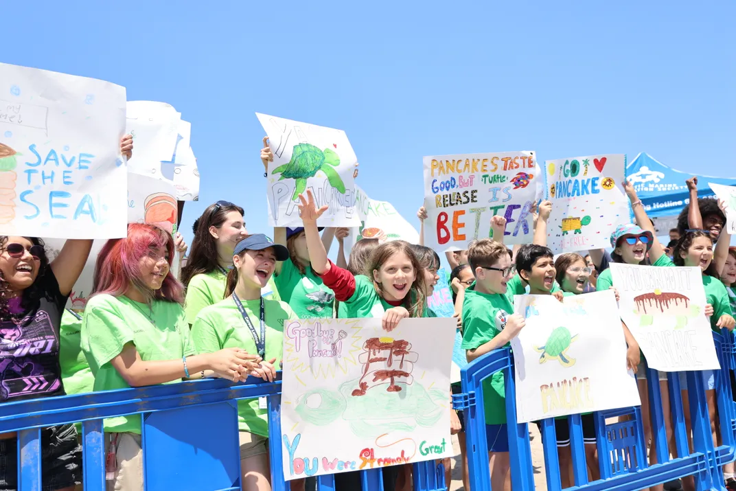 People holding signs and cheering