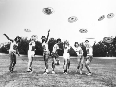A group of Englishmen toss Frisbees in 1966.